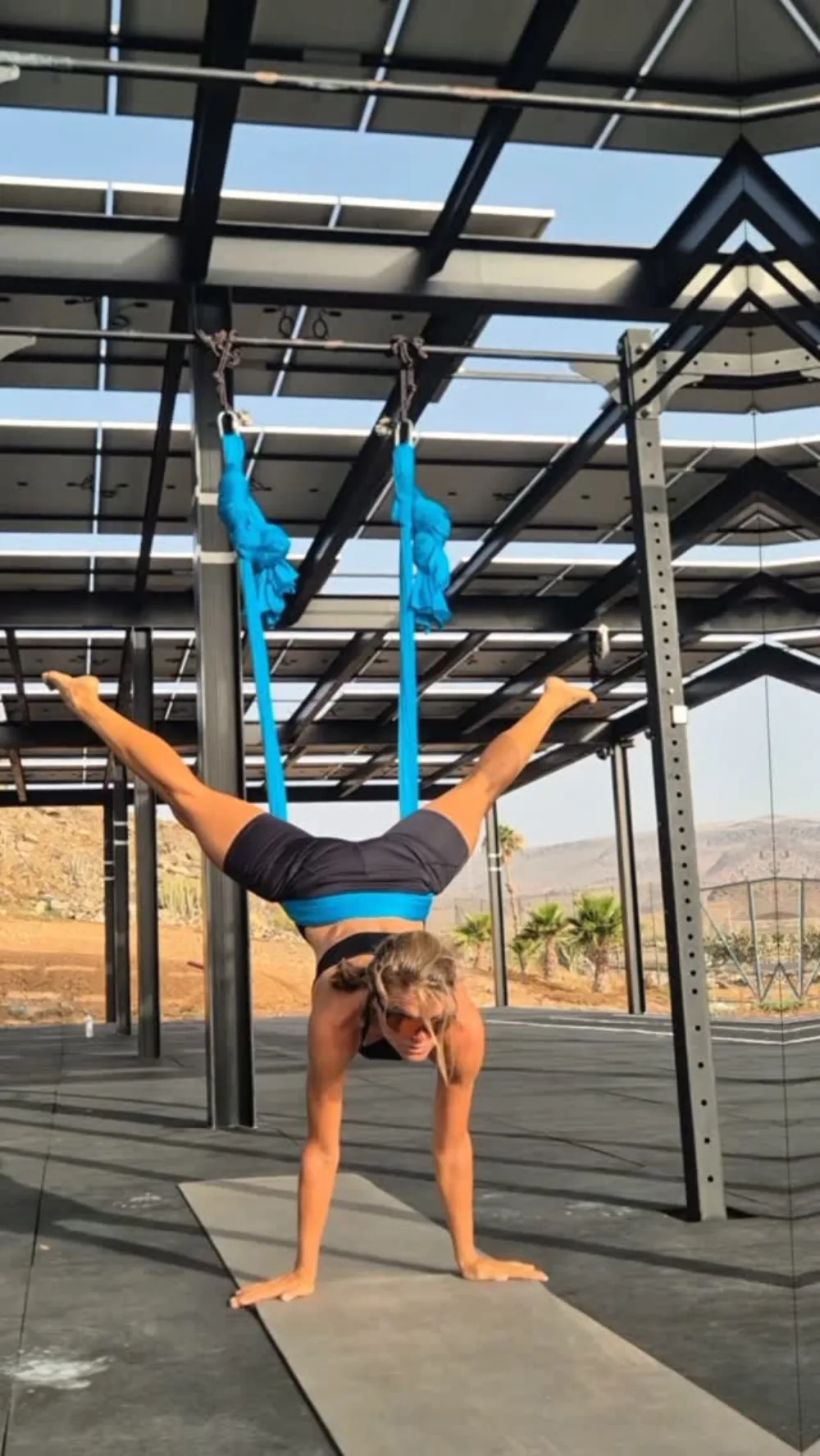 Emma i en aerial yoga-position under soltaket på Monte Feliz, Gran Canaria
