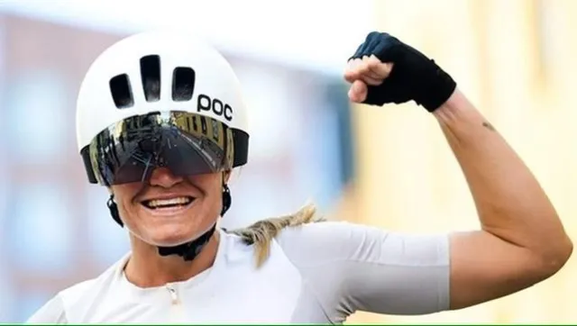 Emma höjer näven i en vit POC-hjälm